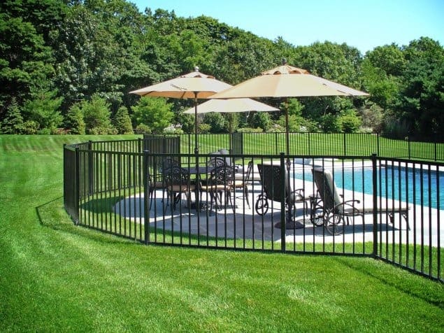 Vertical open-style fence surrounding a landscaped property