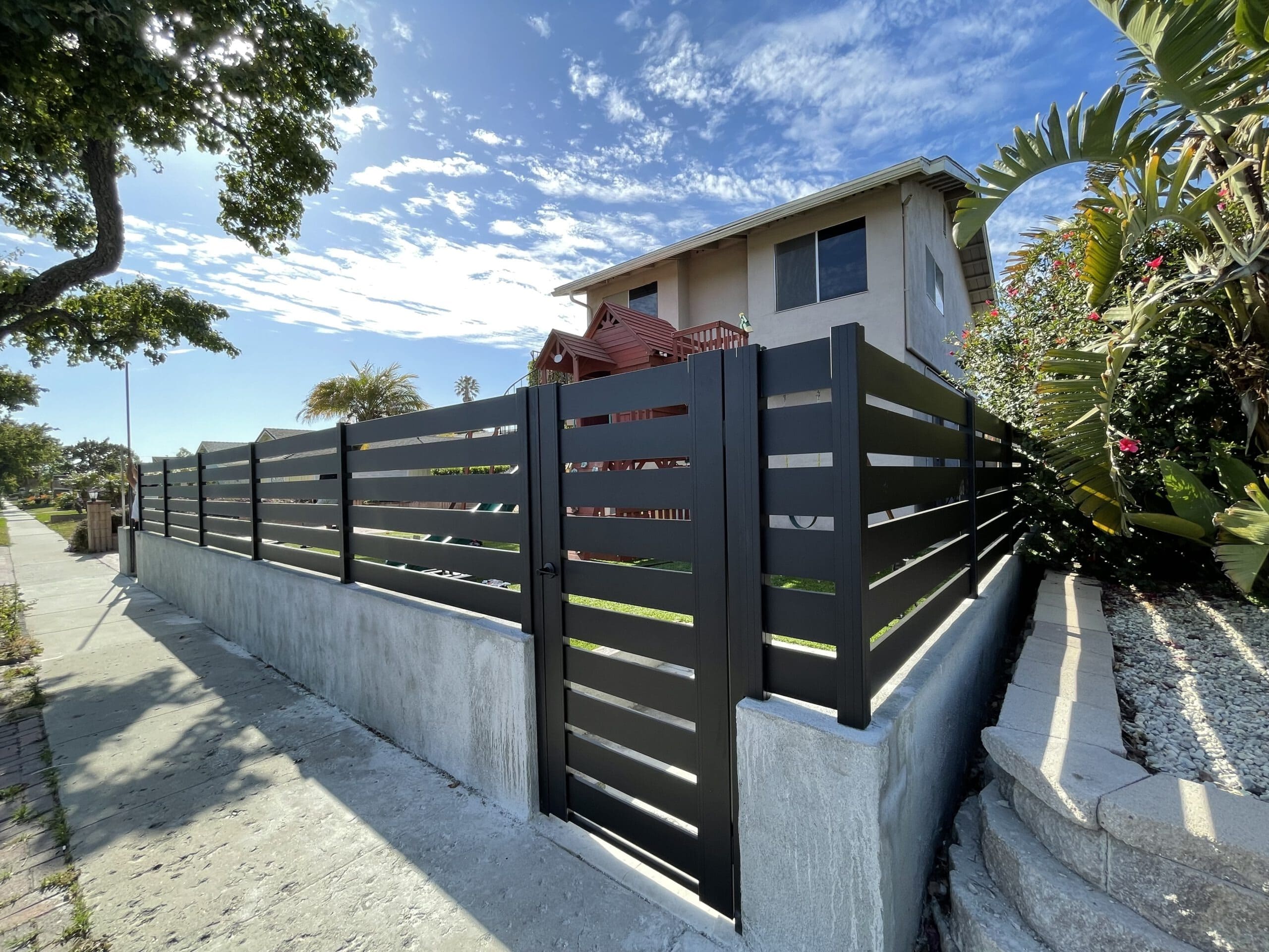 Open slat fence detail with visible spacing between metal members