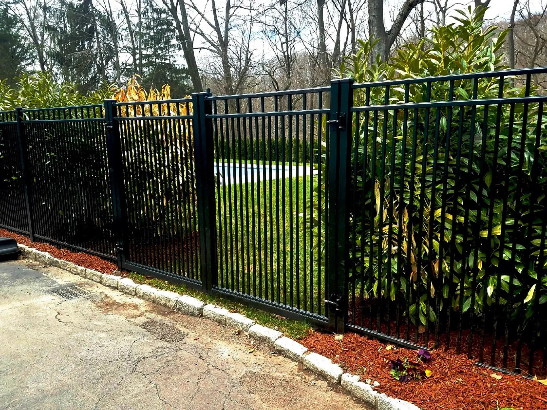 VALUNO aluminum picket fence surrounding a landscaped garden