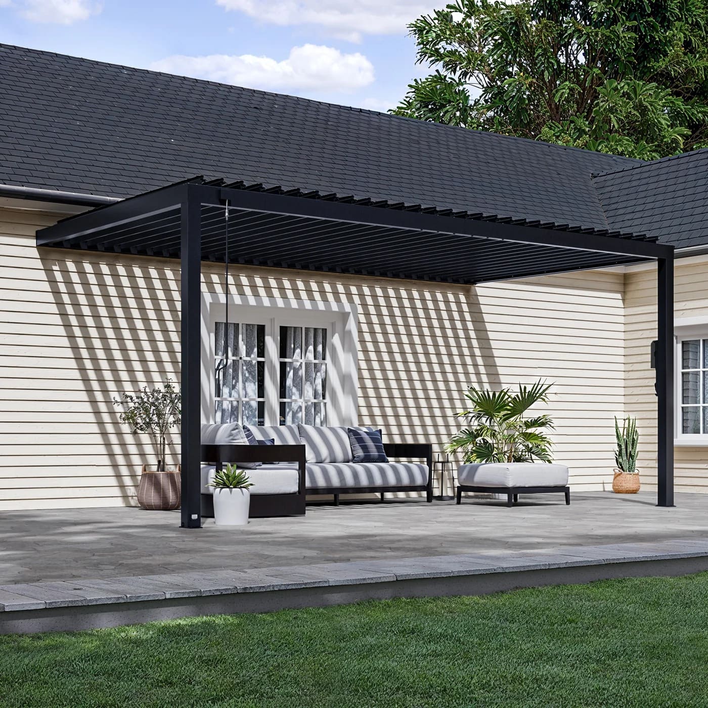 Wall-mounted aluminum pergola installed against a contemporary building facade